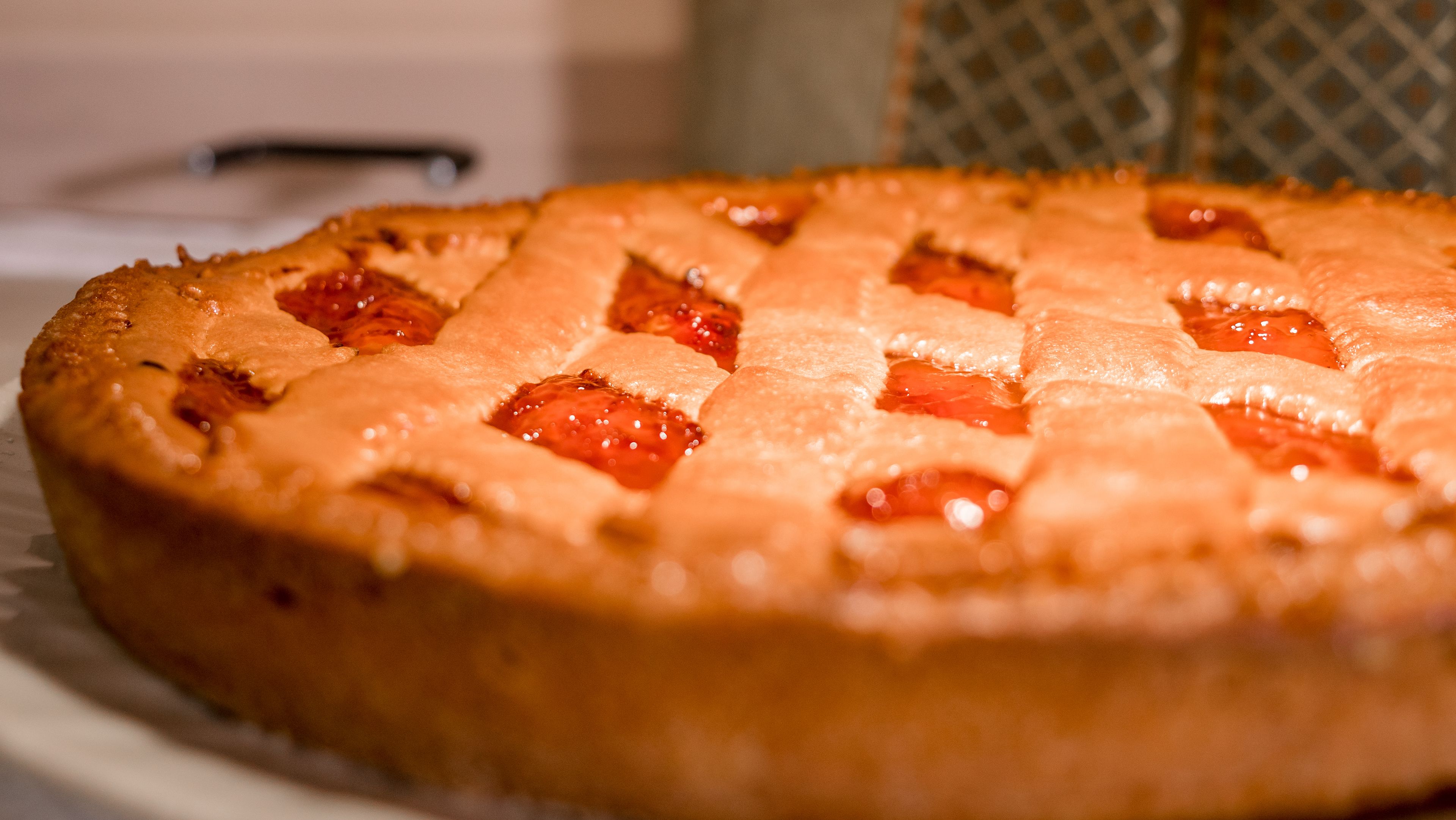 A round fruit tart with a lattice crust on a white plate.