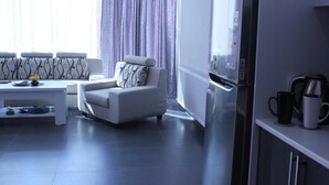 Una sala moderna con un sofá, una mesa de centro y un refrigerador.