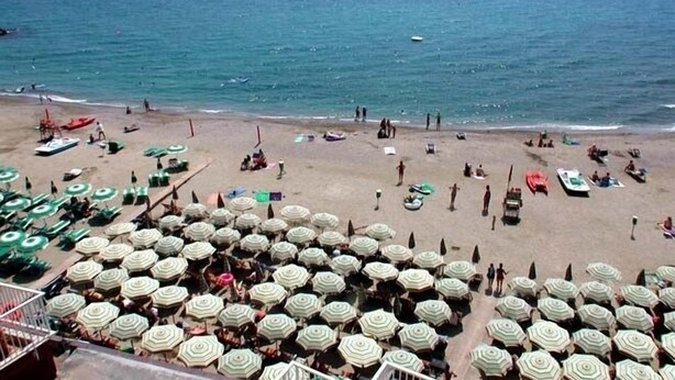 A beach with numerous umbrellas and people. - Residence Stella Maris (Pietra Ligure)