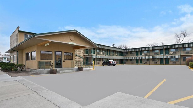 A motel with a single-story building and a two-story parking garage. - Americas Best Value Inn (North Platte)