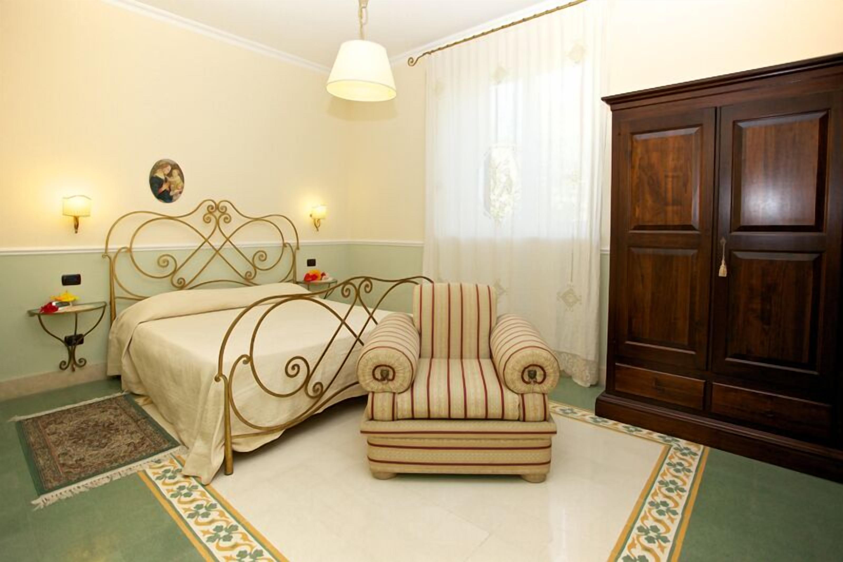 Une chambre à coucher avec un lit, une chaise, une armoire et une lampe.