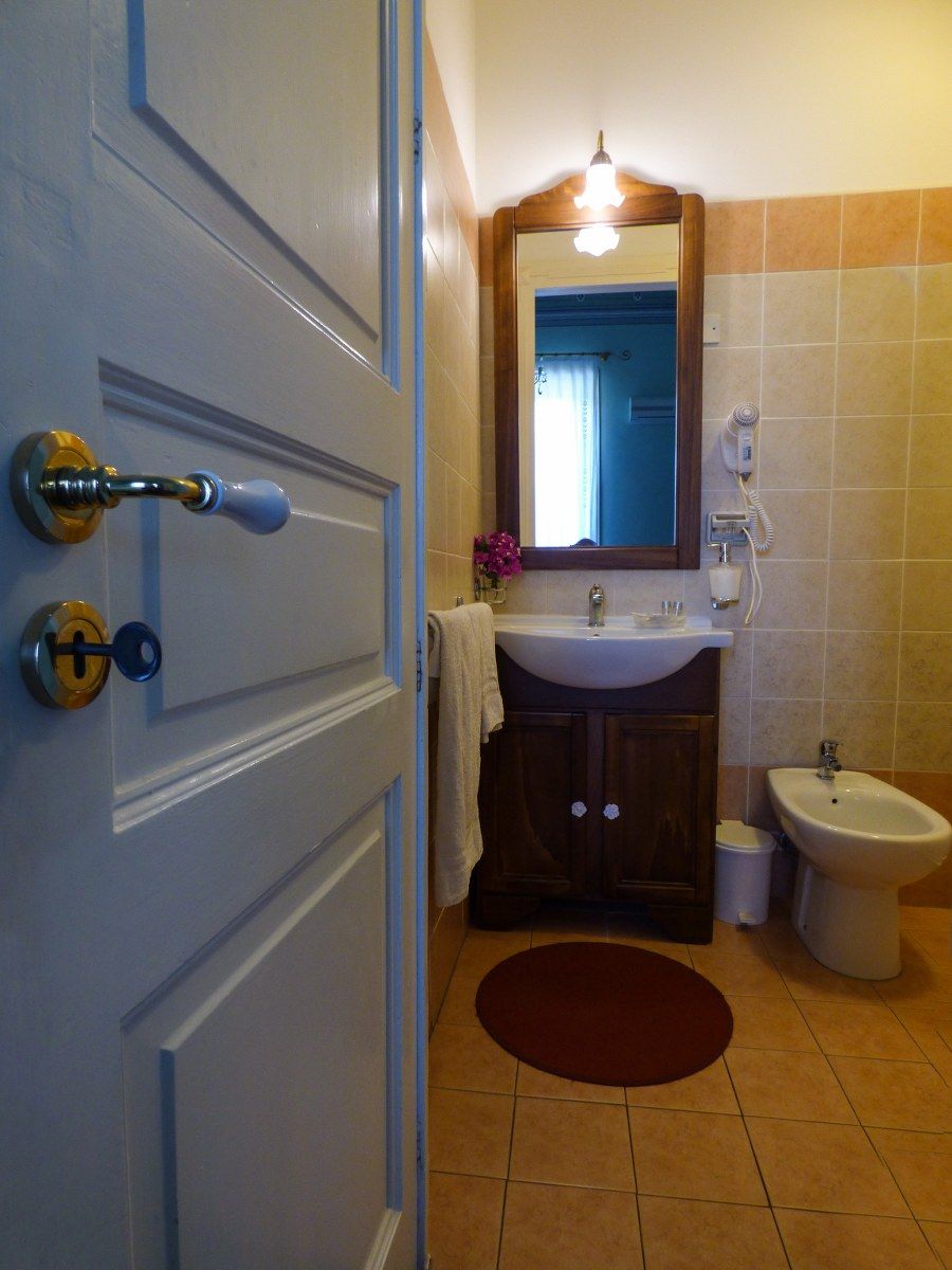 Une salle de bain avec une porte blanche, un lavabo, un bidet et un miroir.
