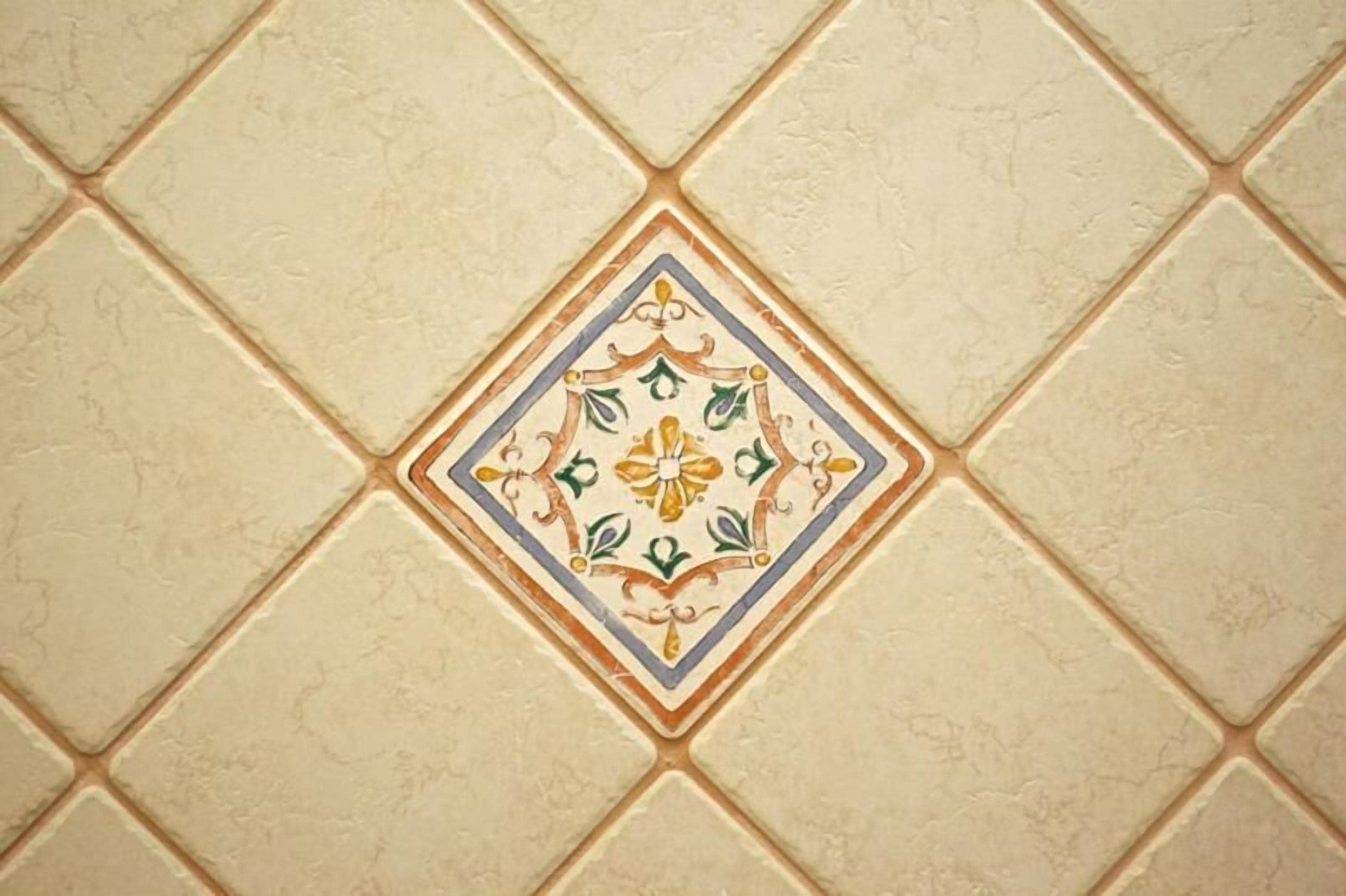 A tiled wall with a central decorative tile featuring a geometric pattern.