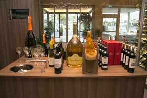 A bar area with various bottles of wine and glasses on a wooden counter. - Hotel Commercio (Battipaglia)