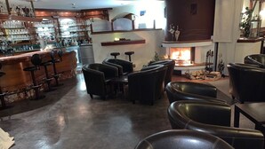 A bar area with stools and a fireplace. - Hotel Donau (Donauwoerth)