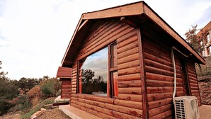 A wooden cabin with a large window and an air conditioning unit outside. - Godence Hotel Restoran (Seferihisar)