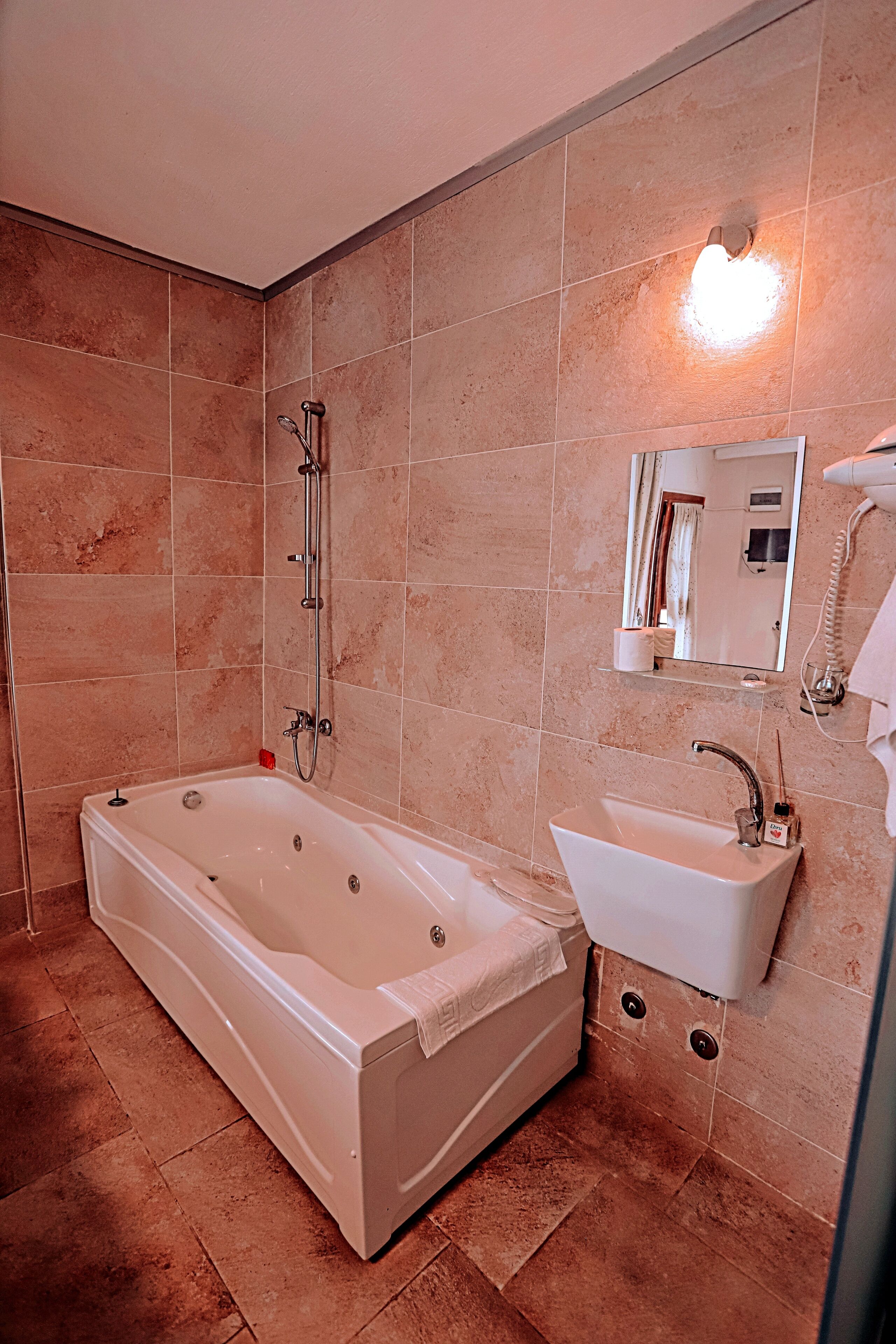 A bathroom with a bathtub, sink, and a mirror.