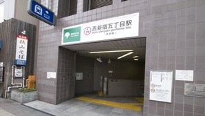 The entrance to a subway station with a sign indicating it is Nishi-shinjuku-gochome Station. - Tokyo Urban Flat Hotel 101 (Tokyo)