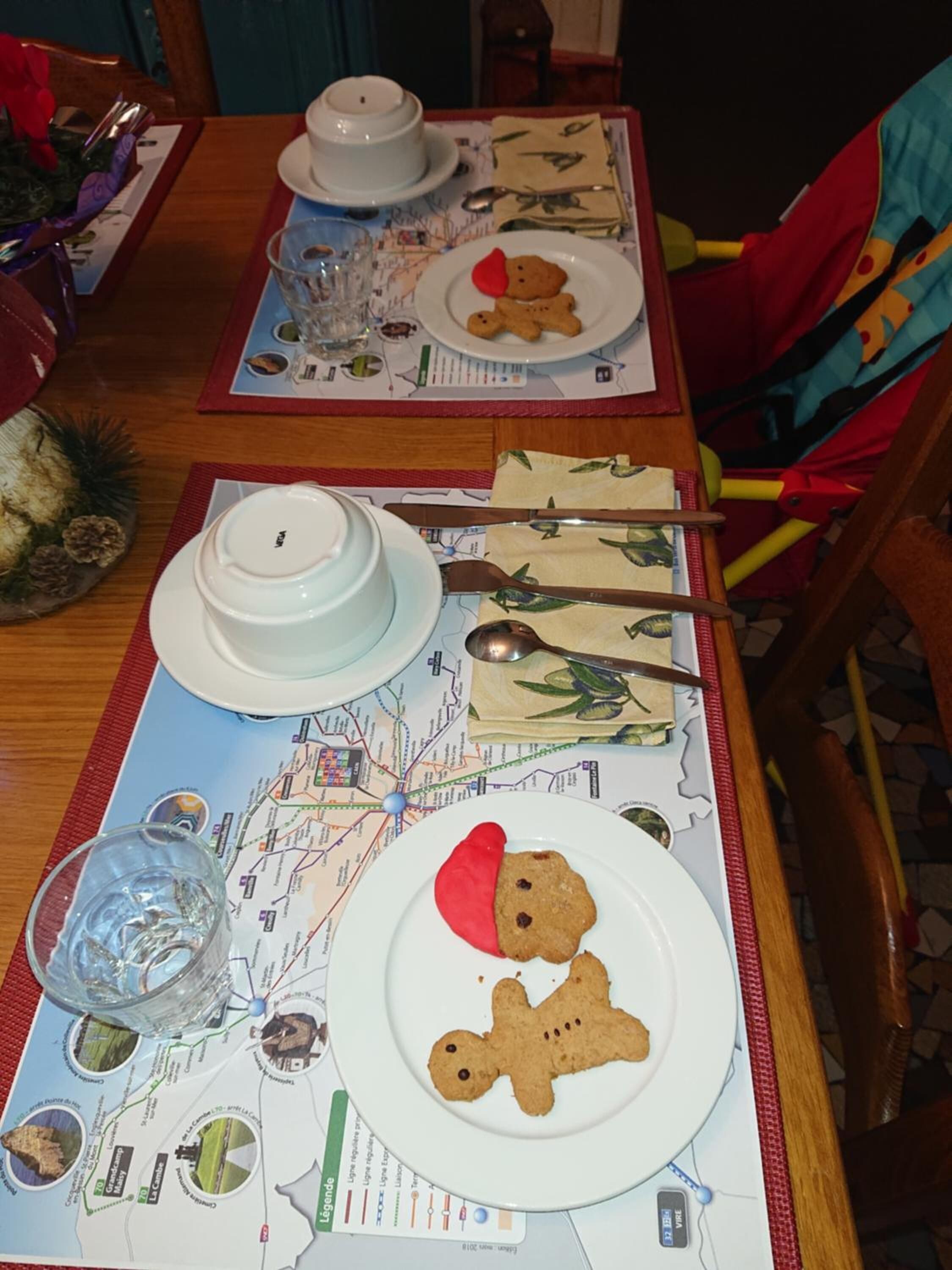 Een eettafel gedekt met borden, bestek en een kaart.