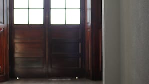 A hallway with a double door, a light fixture, and a wall switch.