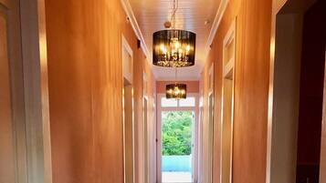 A long, narrow hallway with wooden floors and walls, leading to a bright outdoor area.