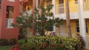 A multi-story hotel with balconies, palm trees, and a landscaped garden. - Cozy apart in a quiet neighborhood, with beautiful views. (NAPLES)