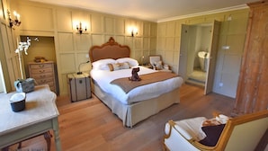 Une chambre à coucher avec un grand lit, des tables de chevet, une commode, une chaise et une armoire.