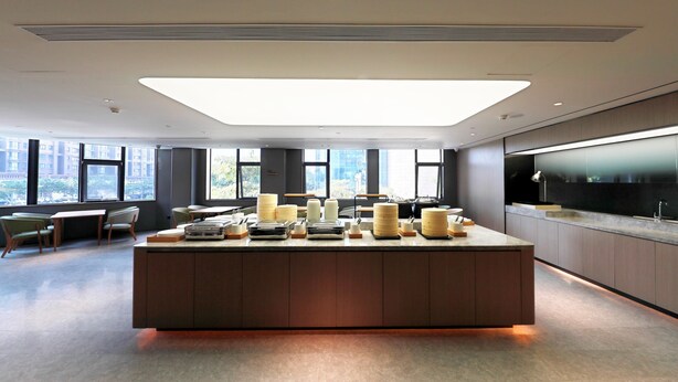 A modern kitchen with a central island, large windows, and a view of the city. - Ji Hotel (xiamen Haicang District Government Branc (Xiamen)
