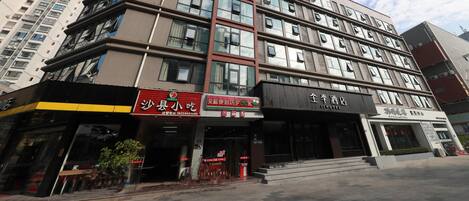 A multi-story hotel with a modern facade, featuring a prominent entrance with a staircase leading to the lobby.
