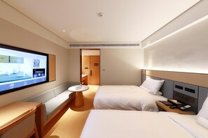 A hotel room with two beds, a desk, a TV, and a small table. - Ji Hotel (xiamen Haicang District Government Branc (Xiamen)