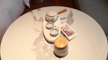 A round marble table with a tea set, a wooden container, and a card.