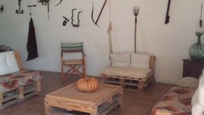 Een rustieke kamer met een houten salontafel, een gestreepte stoel en een bed met een gestreept dekbed.