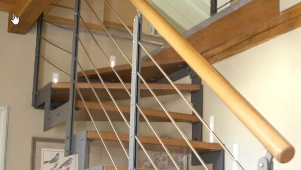 Una escalera con escalones de madera y barandillas de metal.