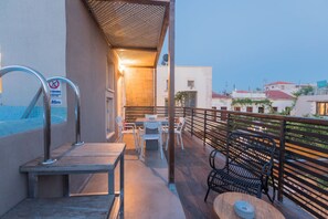 Eine Dachterrasse mit Pool, Sitzgelegenheiten im Freien und einem Sprungbrett.