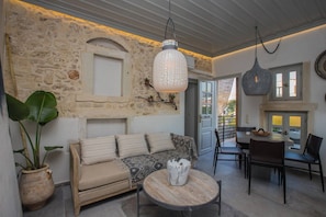 A cozy living area with a stone wall, a sofa, a coffee table, and hanging pendant lights.