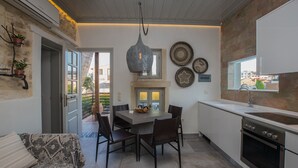 A modern kitchen with a dining table, chairs, and a hanging light fixture. - In the old historical town of Rethymno,Daphne Luxury Home with a private pool (Rethymno)