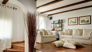 A living room with two white sofas, a bookshelf, and a decorative vase. - Luxury Villa Le Muse between Santa Maria al Bagno and Nardò with swimming pool and Wifi (Santa Maria al Bagno)