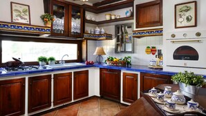 A kitchen with wooden cabinets, a gas stove, a sink, and a window. - Luxury Villa Le Muse between Santa Maria al Bagno and Nardò with swimming pool and Wifi (Santa Maria al Bagno)