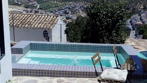 A stone patio with a swimming pool and lounge chairs. - Casa del Arrabal de Montefrío (Montefrio)