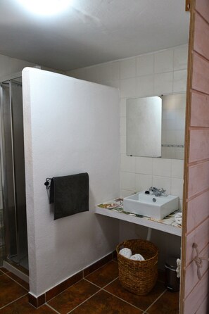A bathroom with a shower, a sink, a mirror, and a towel rack. - Casa del Arrabal de Montefrío (Montefrio)
