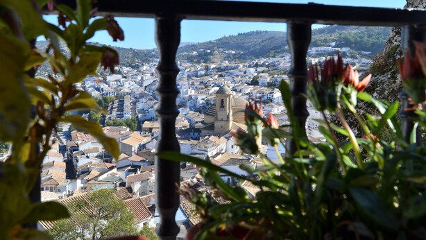 A cityscape with a prominent church dome and a view of a town through a balcony railing. - Casa del Arrabal de Montefrío (Montefrio)
