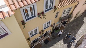 A building with a tiled roof, multiple windows, and hanging flower baskets.