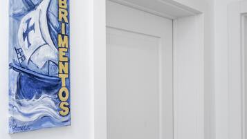 Una puerta blanca con cerradura electrónica y un cuadro de un velero en la pared.