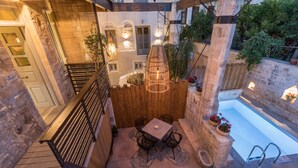 Terrassa al terrat amb piscina, mobiliari exterior i tanca de fusta.