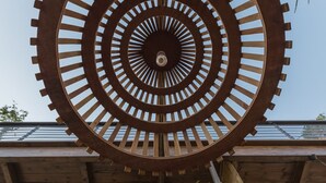 Escultura de metall espiral amb una lluminària central, situada davant de la façana d'un edifici.