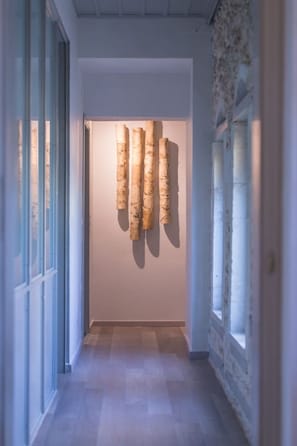 Ein Flur mit einer Holzskulptur, einer Glastür und einem Fenster.