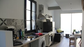 A compact kitchen with a washing machine, a stove, and a microwave. - House "Ile d'Aix" adapted PMR single center Rochefort (Rochefort)