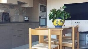 A modern kitchen with wooden cabinets, a dining table with chairs, and a potted plant. - Charming residence in the heart of green Provence (Bras)