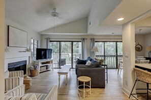 A spacious living area with a fireplace, television, and comfortable seating.