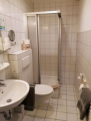 A bathroom with a toilet, sink, and shower.