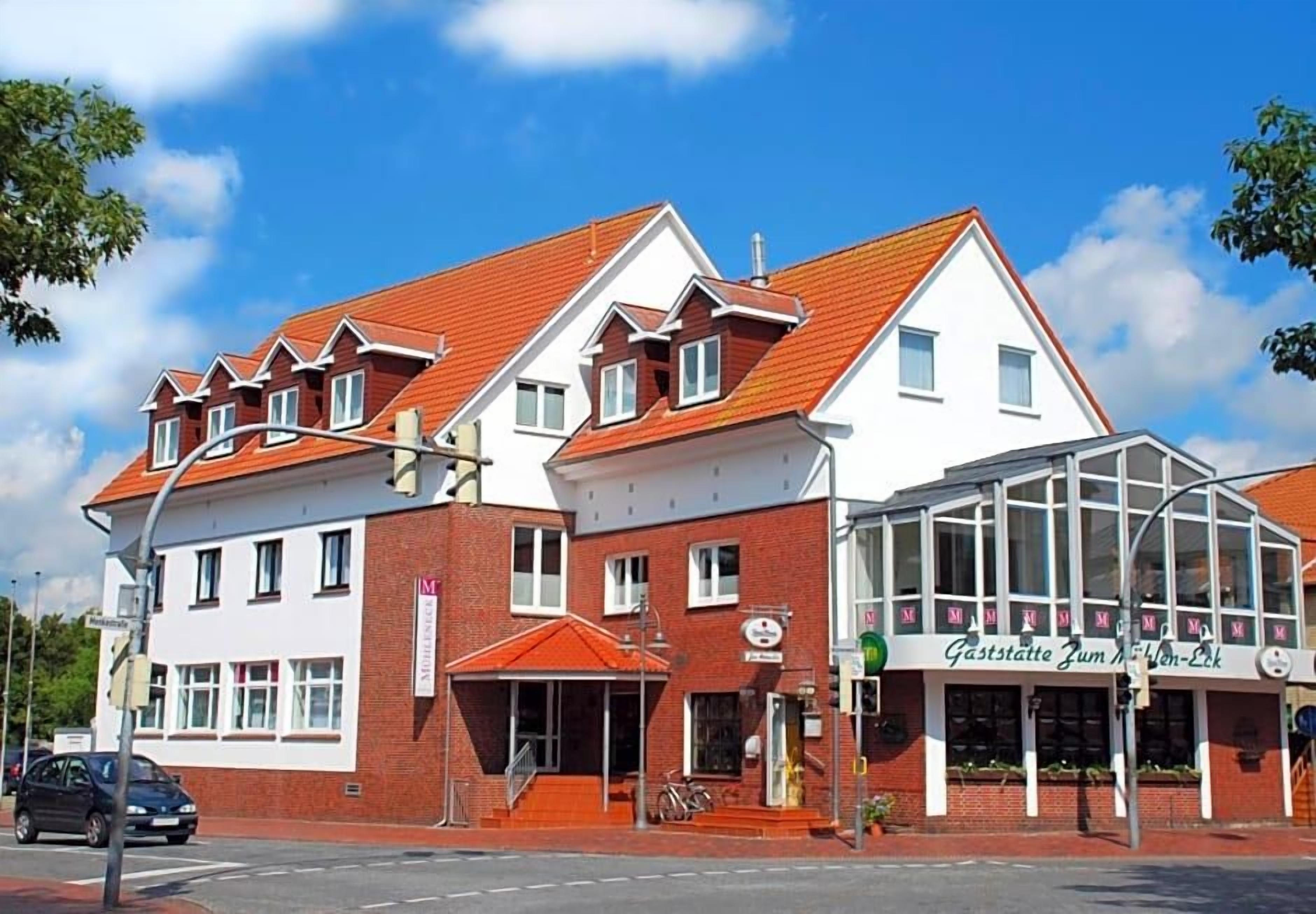 A building with a red-tiled roof, a glass storefront, and a sign that reads 'Gaststätte Zum M.'