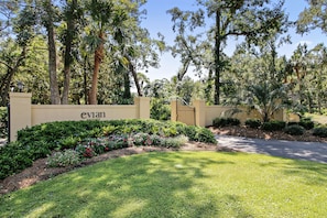 A landscaped entrance with a gate, lush greenery, and a building with 'evan' signage.