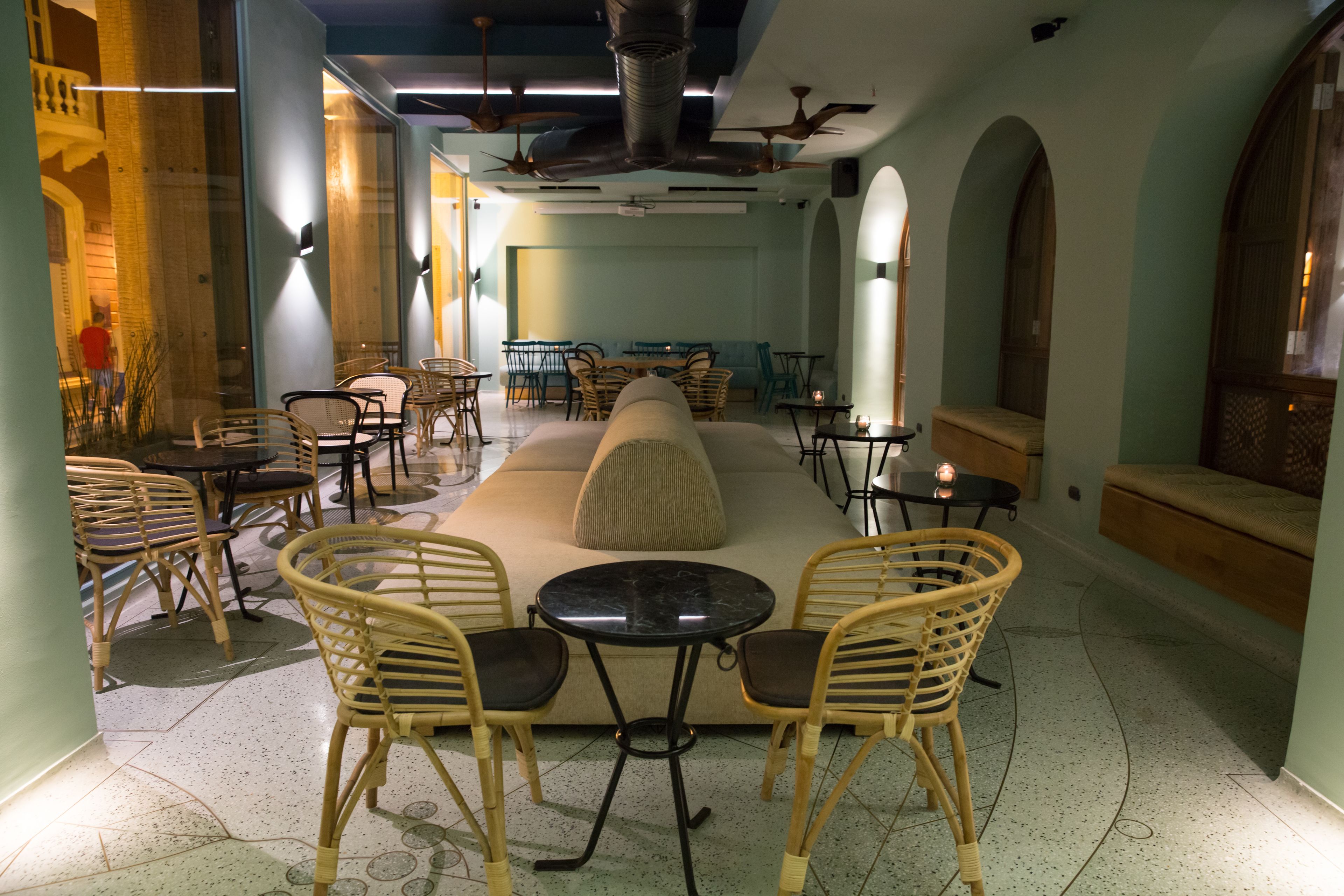 Um interior moderno com uma área de estar central, várias mesas e cadeiras.