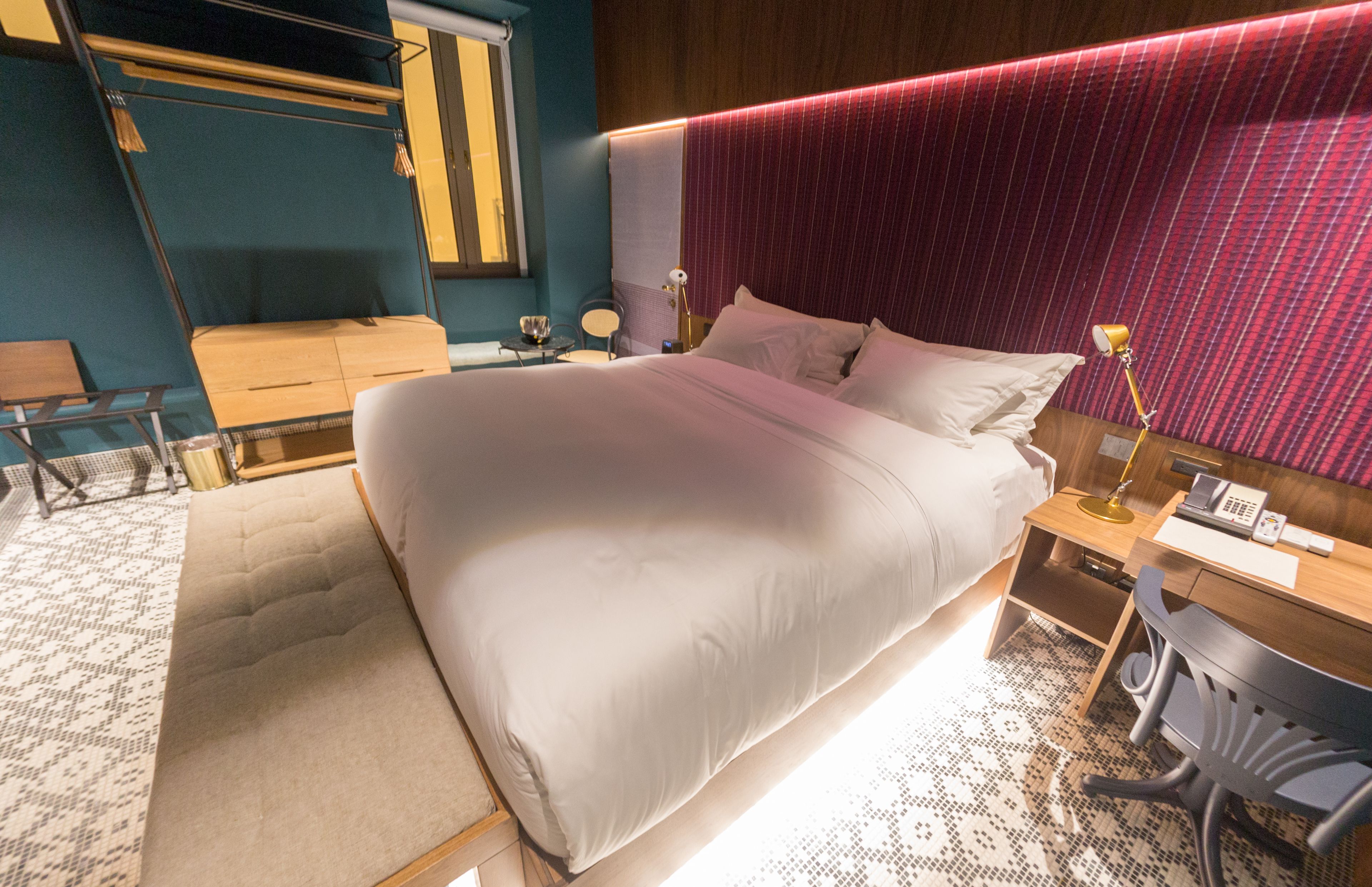 Une chambre d’hôtel moderne, dotée d’un grand lit, d’un bureau et d’une chaise.
