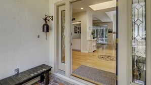 A modern interior with a bench outside a door, a bell, and a doormat. - Sunset Rentals | Mooring Buoy 175 (Hilton Head Island)