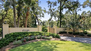 A landscaped entrance with a gate, lush greenery, and a sign for 'evan PRIVATE'. - Sunset Rentals | Evian 257 | Dog Friendly (Hilton Head Island)