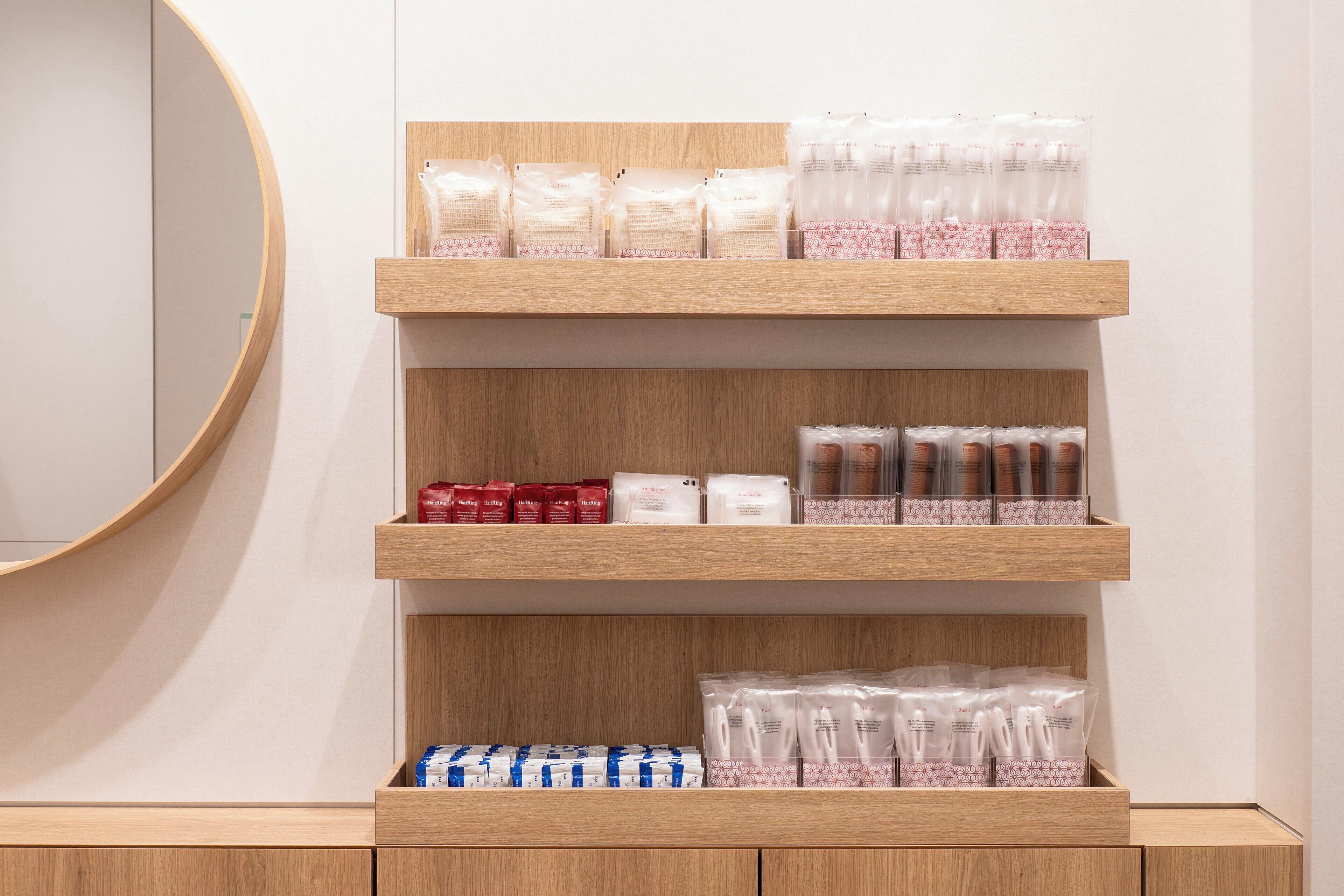 A wooden shelf unit with various packaged items, including what appears to be toiletries and snacks.