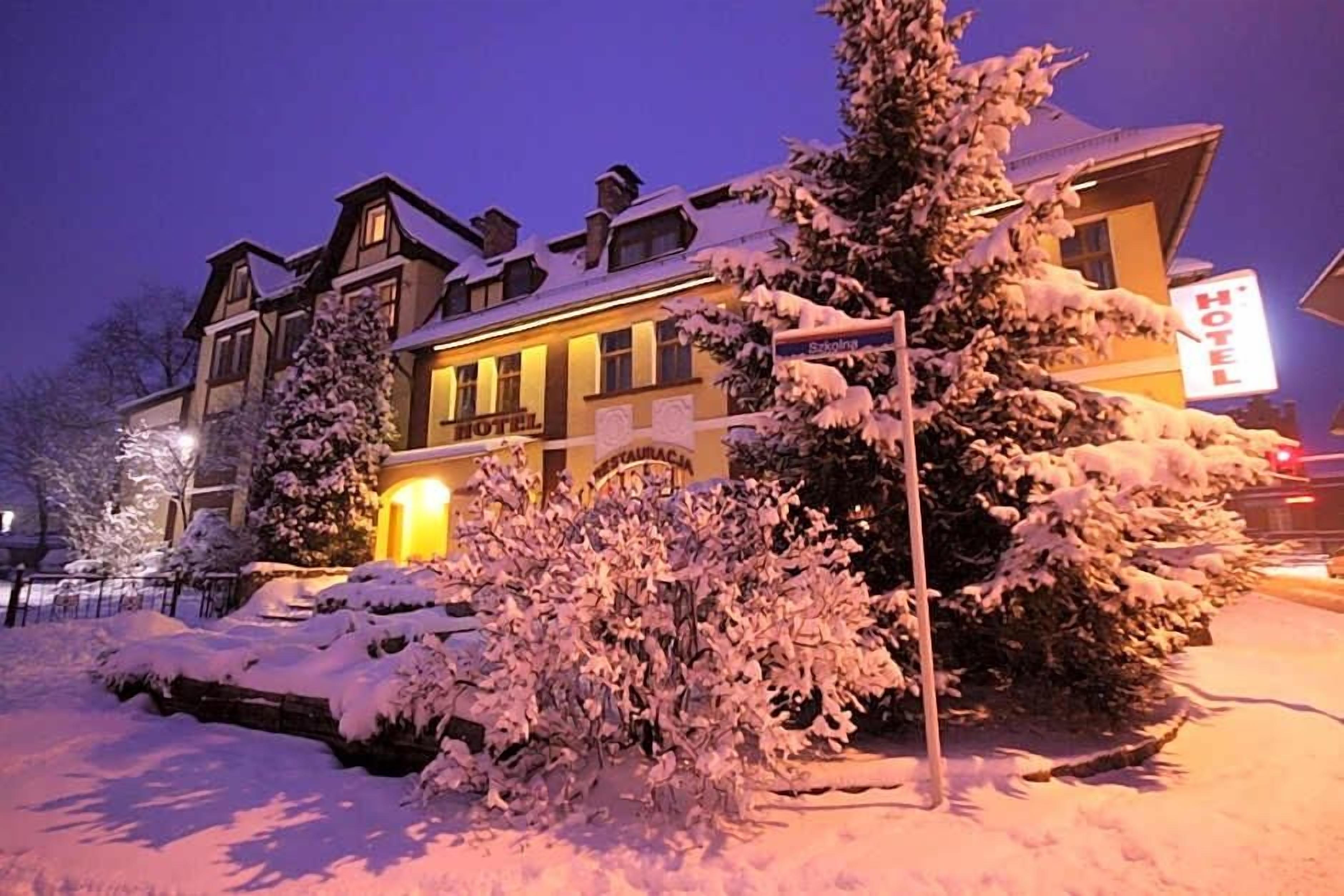 Un hôtel au style architectural traditionnel, caractérisé par une entrée imposante et une enseigne indiquant son nom.