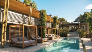 A poolside area with wooden loungers and a covered seating area. - Posada Arenas de José Ignacio (José Ignacio)