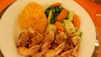 Prato com camarões grelhados, arroz e legumes variados.